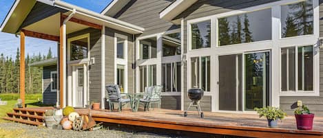 A modern house with a covered patio, large windows, and a deck.