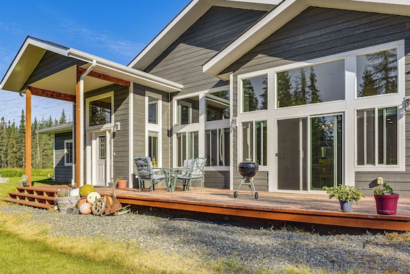 A modern house with a covered patio, large windows, and a deck.
