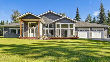 A two-story house with a covered porch, a garage, and a well-maintained lawn.