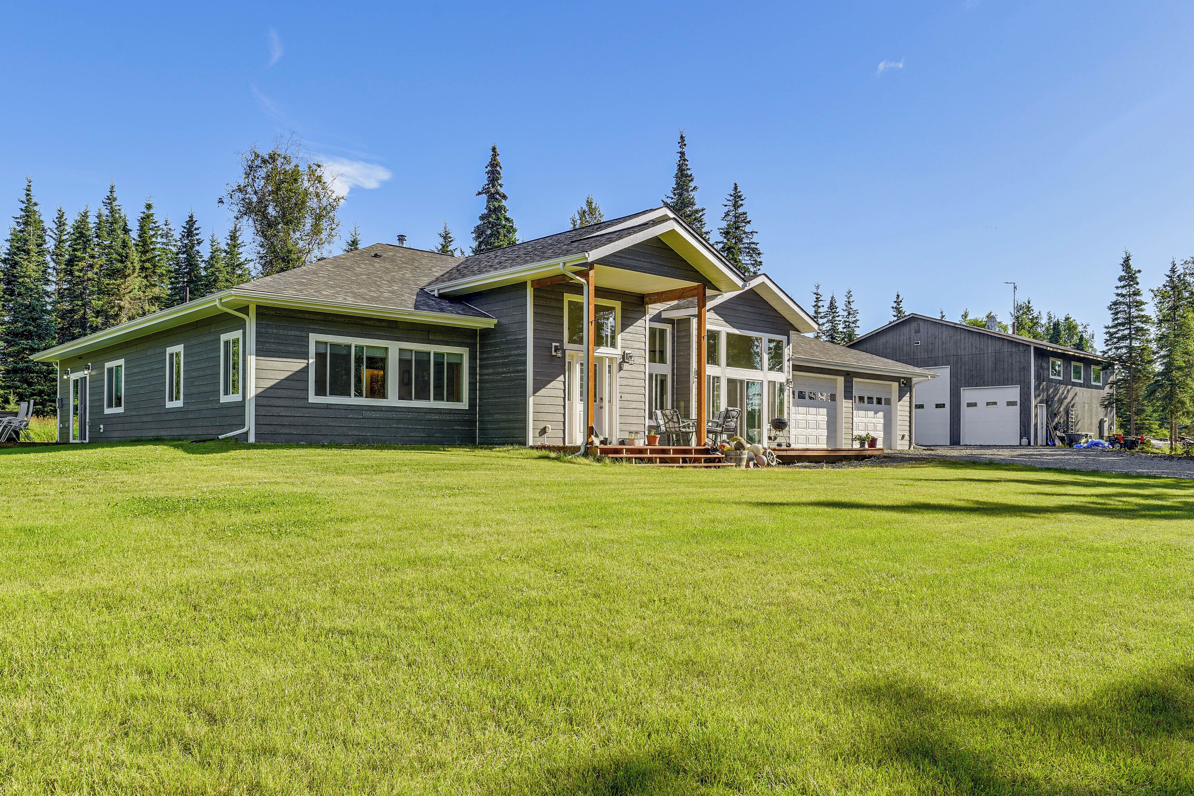 A two-story house with a covered porch, a garage, and a well-maintained lawn.