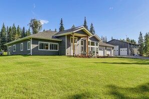 A two-story house with a covered porch, a garage, and a well-maintained lawn.