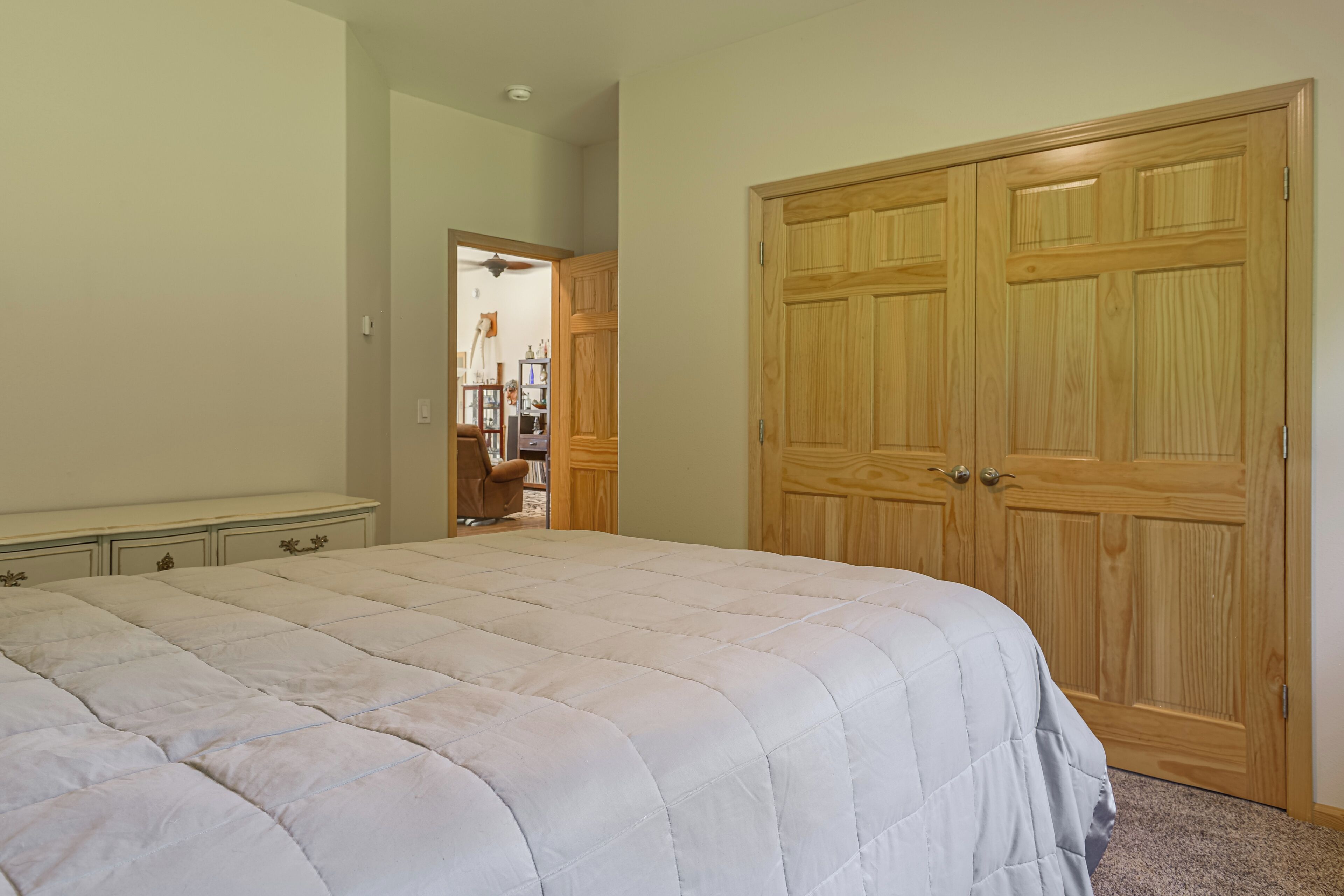 A bedroom with a large bed, a wardrobe, and a chair.