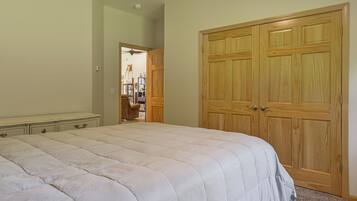 A bedroom with a large bed, a wardrobe, and a chair.
