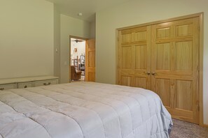 A bedroom with a large bed, a wardrobe, and a chair. - Exquisite Private Home Retreat Near Kenai River (Soldotna)