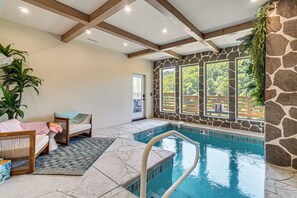 A pool area with a stone wall, a bench, and a view of the outdoors. - Brand-new Smokies Cabin w/ Spectacular Mtn Views (Sevierville)