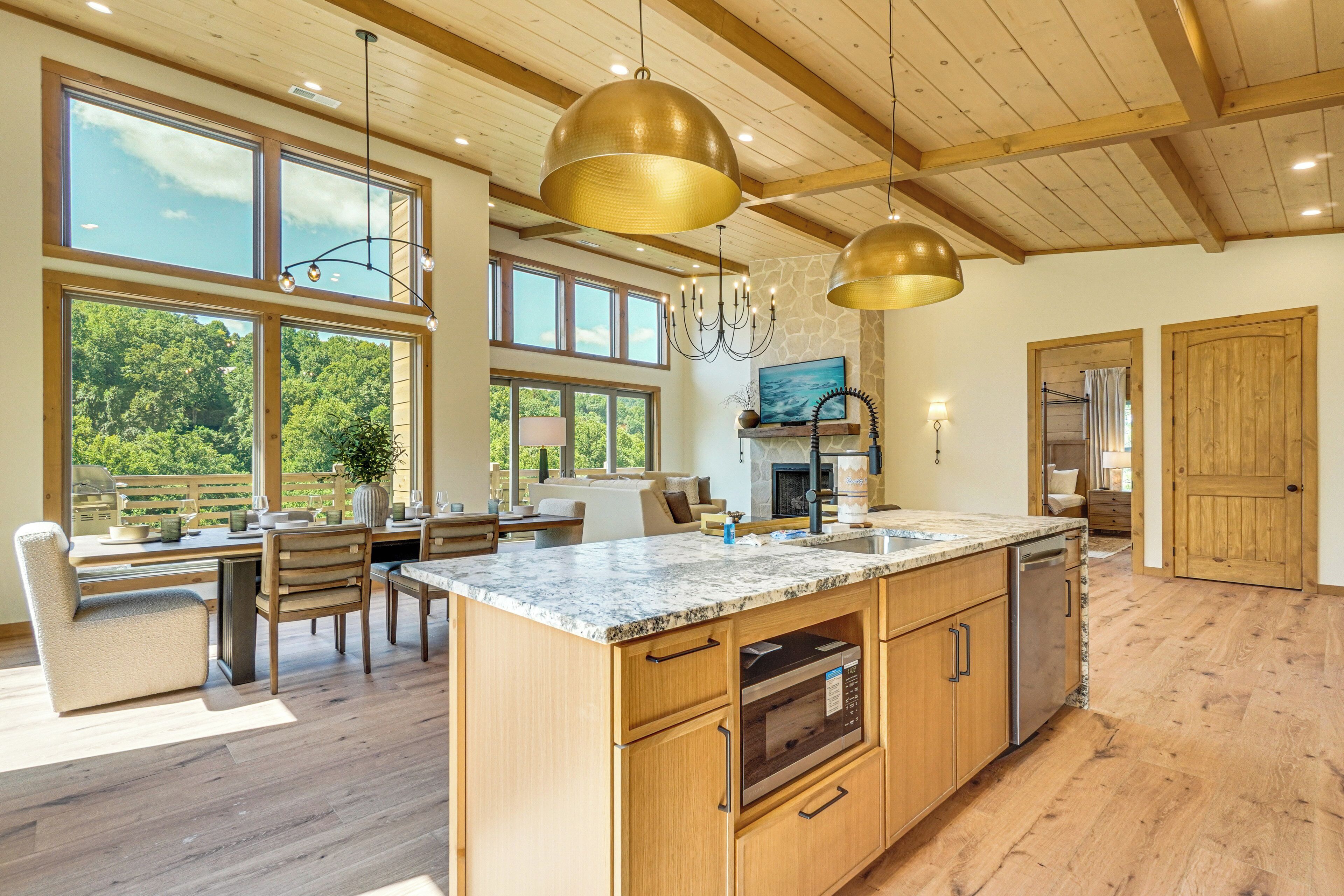 A spacious kitchen with a large island, wooden cabinets, and a stone backsplash.