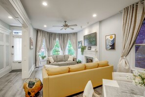 A living room with a sofa, a coffee table, and a fireplace. - Private Patio & Hot Tub! Urban STL Retreat (St. Louis)