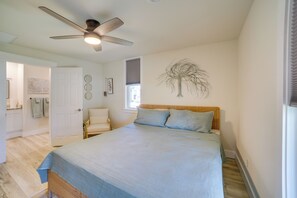 A bedroom with a bed, a ceiling fan, a wall art of a tree, and a window with blinds. - 7 Mi to Roaring River State Park! Gem w/ Fire Pit (Cassville)