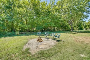An outdoor seating area with three chairs and a fire pit.