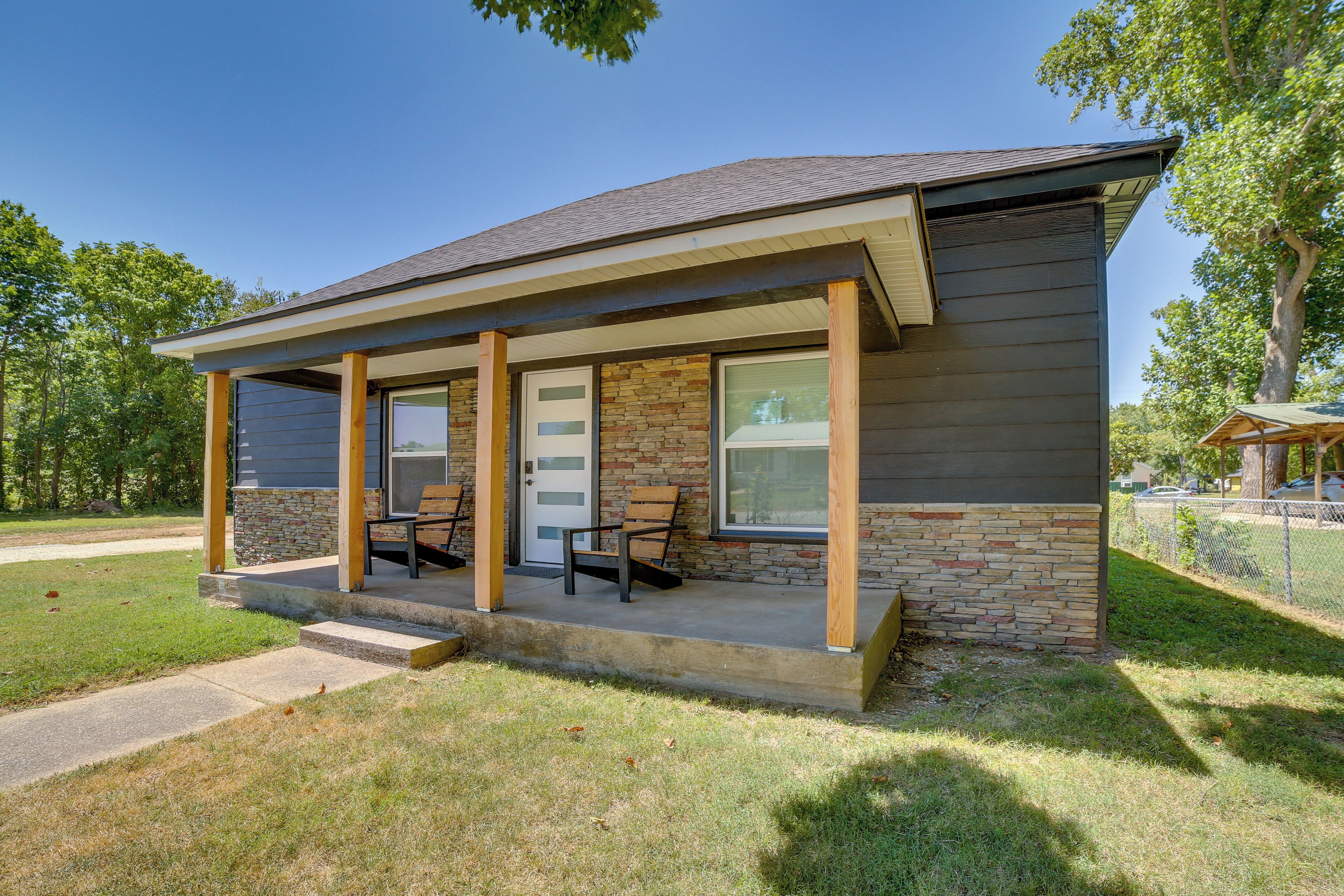 A single-story building with a porch, a door, and two windows.