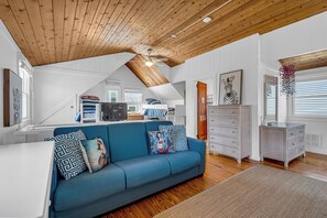 A spacious living area with a blue sofa, wooden ceiling, and white walls. - Normandy Beach! Phenomenal Ocean Block Location (Lavallette)