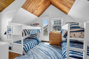 A bedroom with a sloped ceiling, bunk beds, a dresser, and a window. - Normandy Beach! Phenomenal Ocean Block Location (Lavallette)