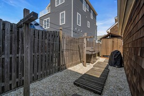 A backyard with a wooden deck, a barbecue grill, and a house with a grey exterior. - Normandy Beach! Phenomenal Ocean Block Location (Lavallette)