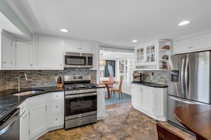 A modern kitchen with white cabinets, stainless steel appliances, and a tiled backsplash. - Normandy Beach! Phenomenal Ocean Block Location (Lavallette)