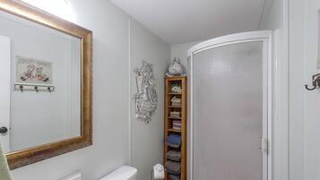 A bathroom with a white toilet, a sink with a mirror, and a towel rack.