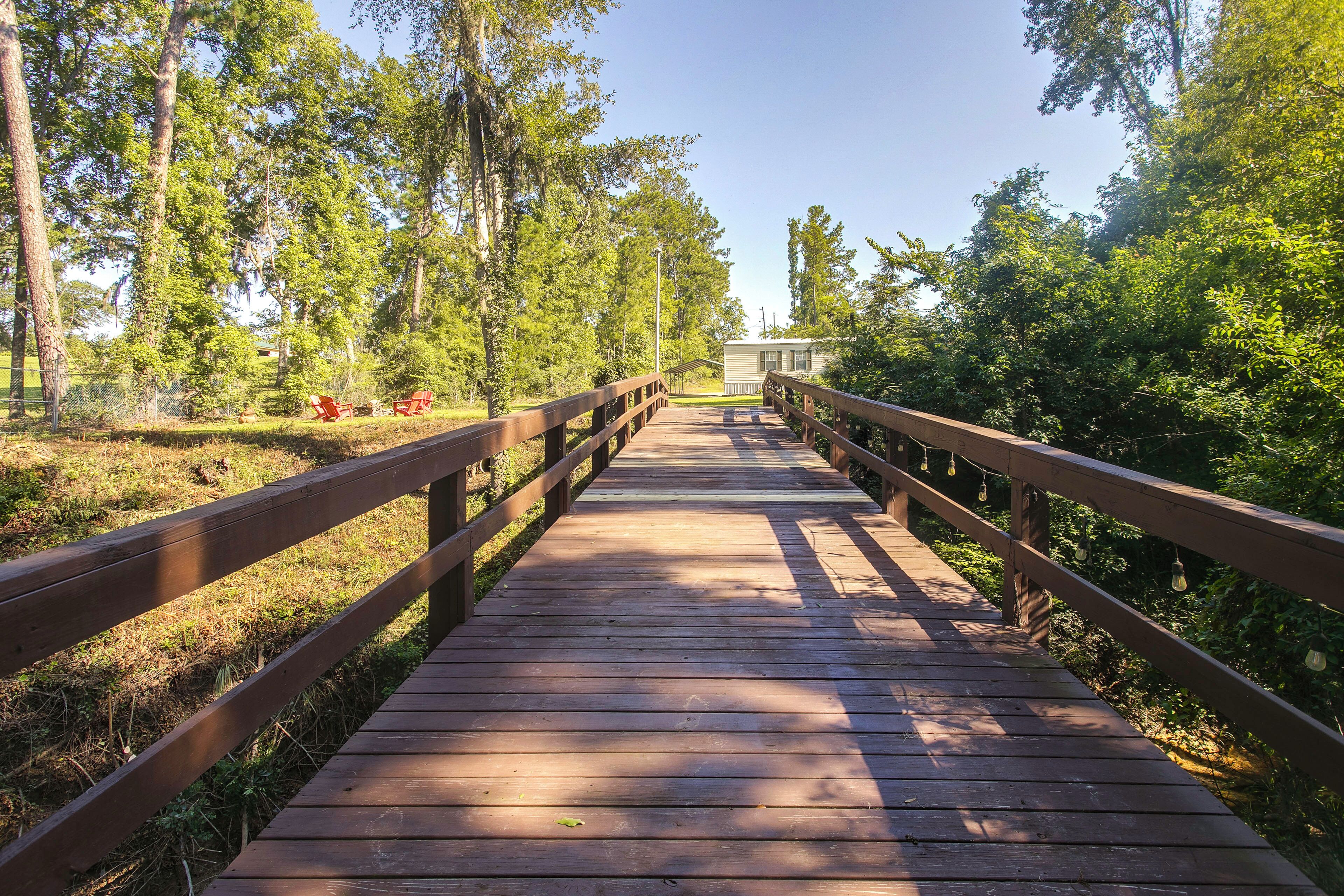A wooden boardwalk leading to a building surrounded by trees.