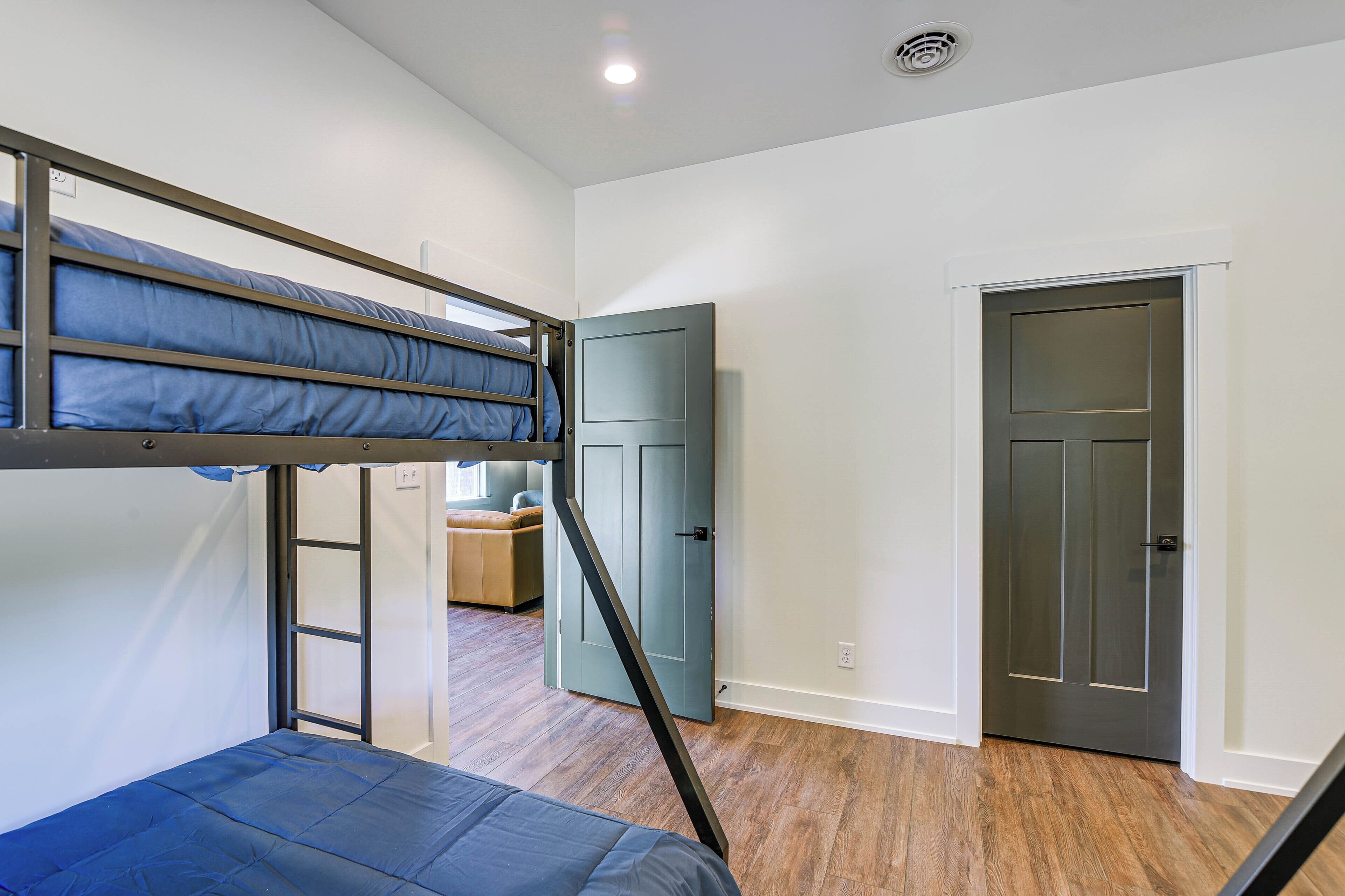 A room with a bunk bed, a wardrobe, and a door.