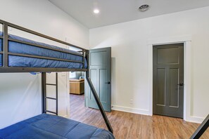 A room with a bunk bed, a wardrobe, and a door. - Brand New, Hot Tub & Porch, Near Nolin Lake! (Clarkson)