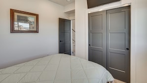 Ein Schlafzimmer mit einem Bett, einem gerahmten Bild an der Wand und einer Doppeltür.