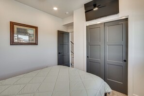 A bedroom with a bed, a framed picture on the wall, and a set of double doors. - Game Room & Stunning Mtn Views! Cedar City Home (Cedar City)