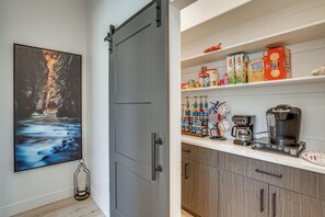 A kitchen with a coffee maker, shelves stocked with cereal boxes, and a painting of a river. - Game Room & Stunning Mtn Views! Cedar City Home (Cedar City)