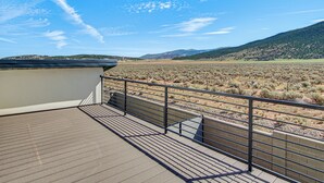 Ein Balkon mit Blick auf eine Wüstenlandschaft und ferne Hügel.