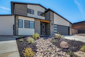 A modern two-story house with a stone and gravel front yard, a garage, and a clear sky. - Game Room & Stunning Mtn Views! Cedar City Home (Cedar City)