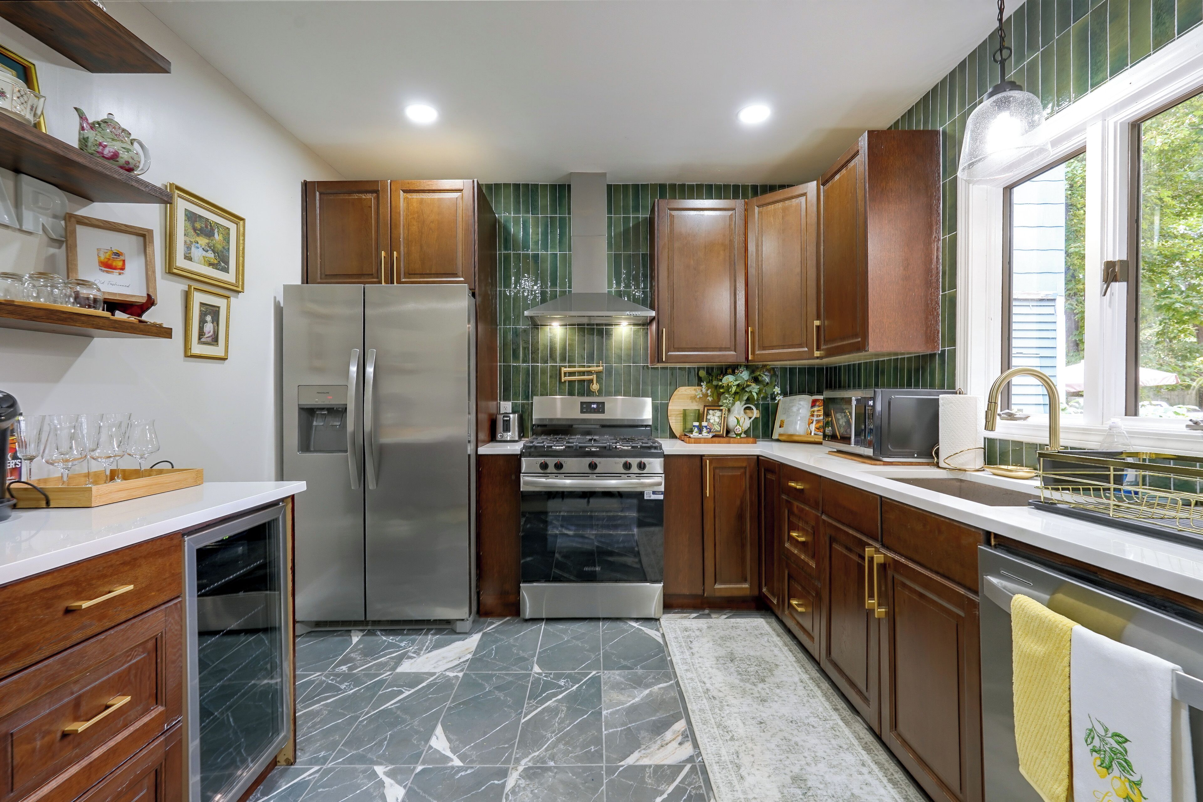 A kitchen with wooden cabinets, a stainless steel refrigerator, a stove, and a microwave.