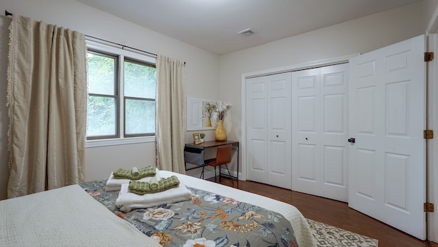 Quarto com cama, escrivaninha e guarda-roupa.
