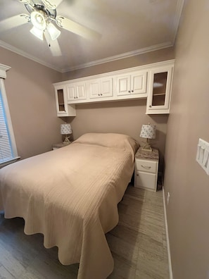 A bedroom with a bed, nightstands, a ceiling fan, and built-in cabinets. - Tranquil 1-bedroom house with AC in Crystal River- Pause and Relax (Crystal River)