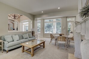 Ein geräumiges Wohnzimmer mit Sofa, Couchtisch und Essbereich mit Stühlen.