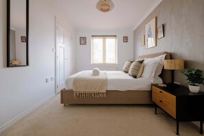 A bedroom with a bed, bedside table, lamp, and a window. - The Travelers Rest - Central Frome (Somerset)
