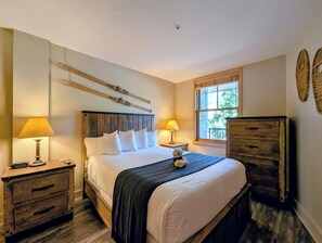 A bedroom with a wooden bed, two bedside tables with lamps, a window, and a dresser. - New Keystone Oasis | Walk to Slopes | Hot tubs (Keystone)