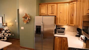 A kitchen with wooden cabinets, a stainless steel refrigerator, a built-in oven, and a gas stove.