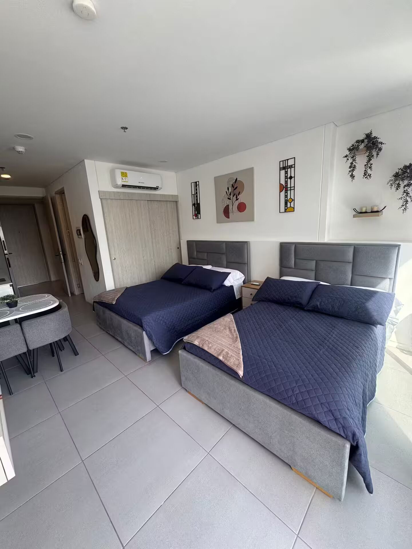 Une chambre d’hôtel avec deux lits, un bureau et une chaise.