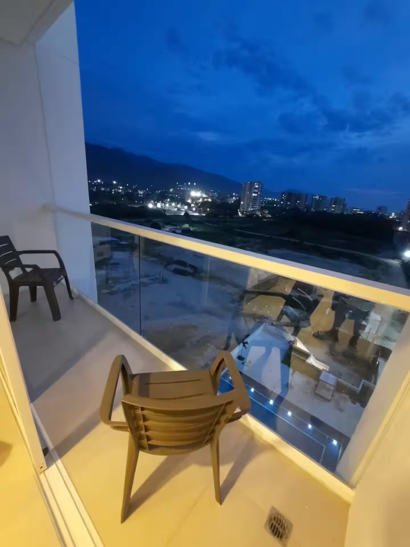 Un balcon donnant sur une vue panoramique de la ville au crépuscule.