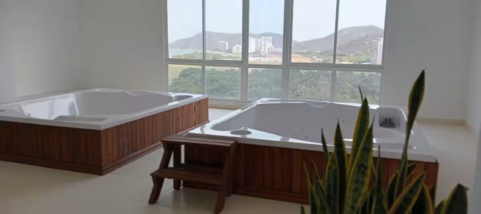Una habitación con dos tinas de madera y un taburete pequeño de madera.