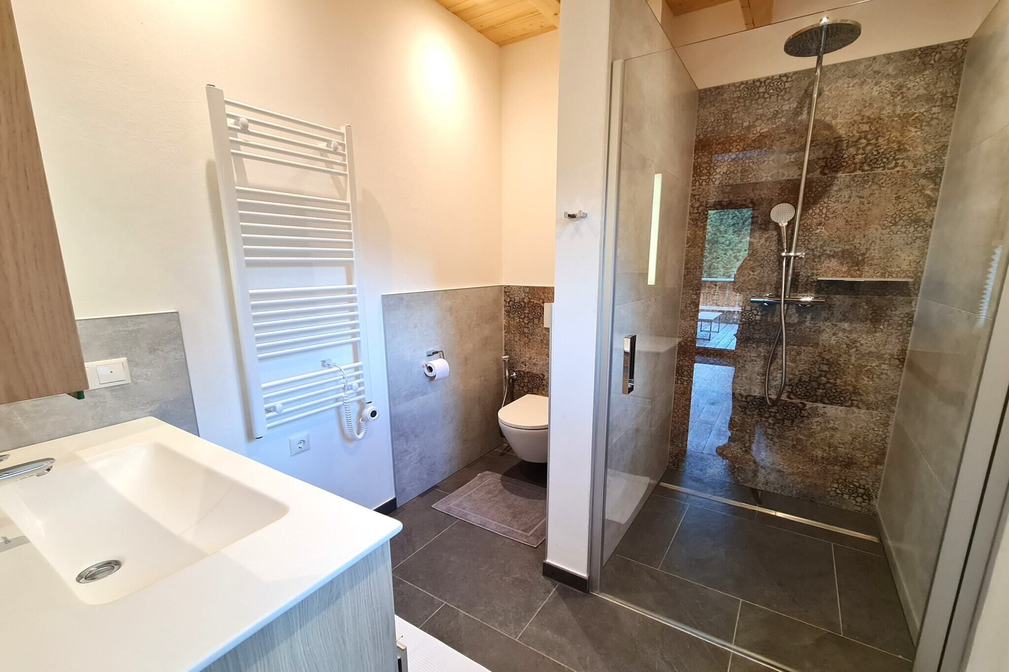 Een moderne badkamer met douche, toilet en wastafel.