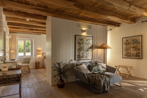 A cozy living room with a wooden ceiling, a grey sofa, a floor lamp, and a large framed bird illustration on the wall. - Villa with Pool near Motovun in Istrian Village (Prašćari)