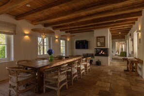 A spacious dining area with a long wooden table, wicker chairs, and a fireplace. - Villa with Pool near Motovun in Istrian Village (Prašćari)