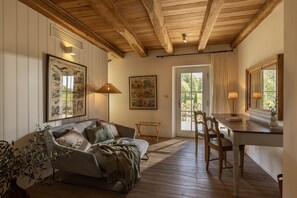 A cozy room with a wooden ceiling, a sofa with cushions, a dining table with chairs, and framed pictures on the walls. - Villa with Pool near Motovun in Istrian Village (Prašćari)