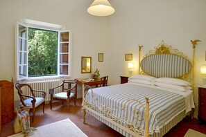 A bedroom with a bed, a desk, chairs, a radiator, and a window with an open shutter. - Wonderful private villa with private pool, WIFI, TV, patio and panoramic view, close to Pisa (Fauglia)