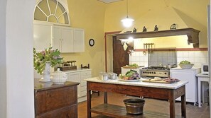A kitchen with a wooden table, cabinets, a stove, and various kitchen items. - Wonderful private villa with private pool, WIFI, TV, patio and panoramic view, close to Pisa (Fauglia)