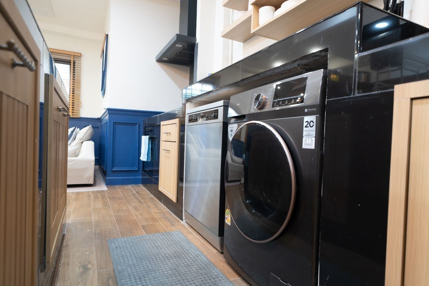 A compact kitchen with a washing machine, a dishwasher, and a refrigerator.