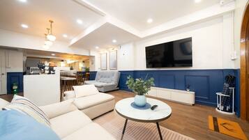 A modern living room with a sofa, a coffee table, and a TV mounted on the wall.