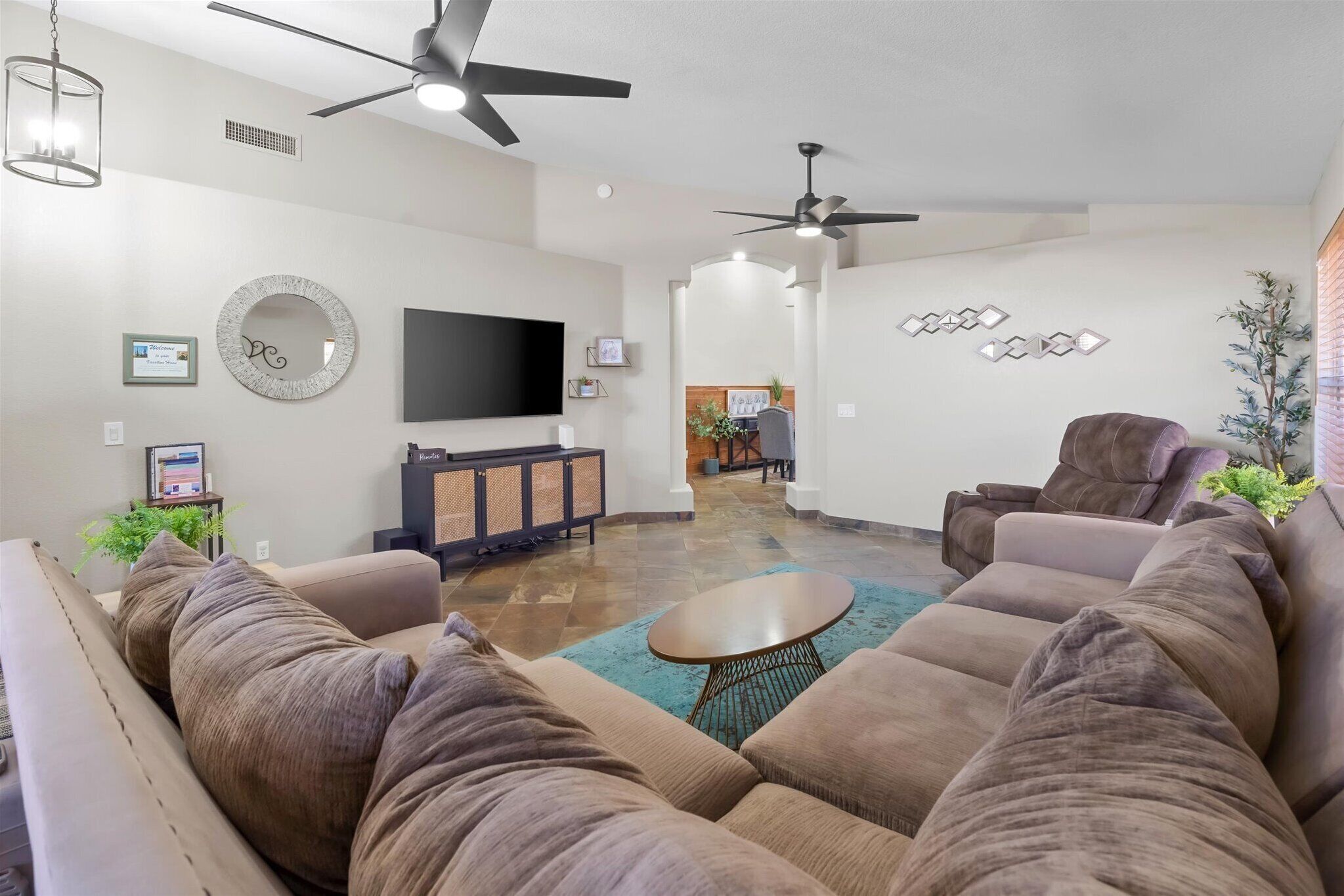 Spacious living room with a large sectional, recliner, and TV for movie nights or relaxing after a day around Peoria.