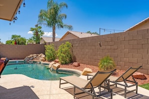 Poolside loungers overlook the private pool and waterfall feature — an easy place to spend a sunny Peoria afternoon.
