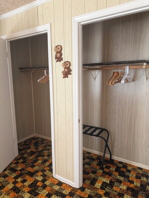 A closet with hanging space and a bench.