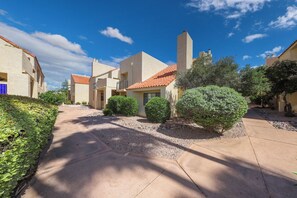 A residential area with houses featuring red-tiled roofs and stucco walls, surrounded by well-maintained landscaping and a clear sky. - Dramatic end unit 2 bedrm split floor plan   B26 Great central location (Tucson)