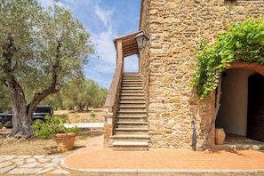 Una scala in pietra che conduce a un edificio con un tetto in legno.